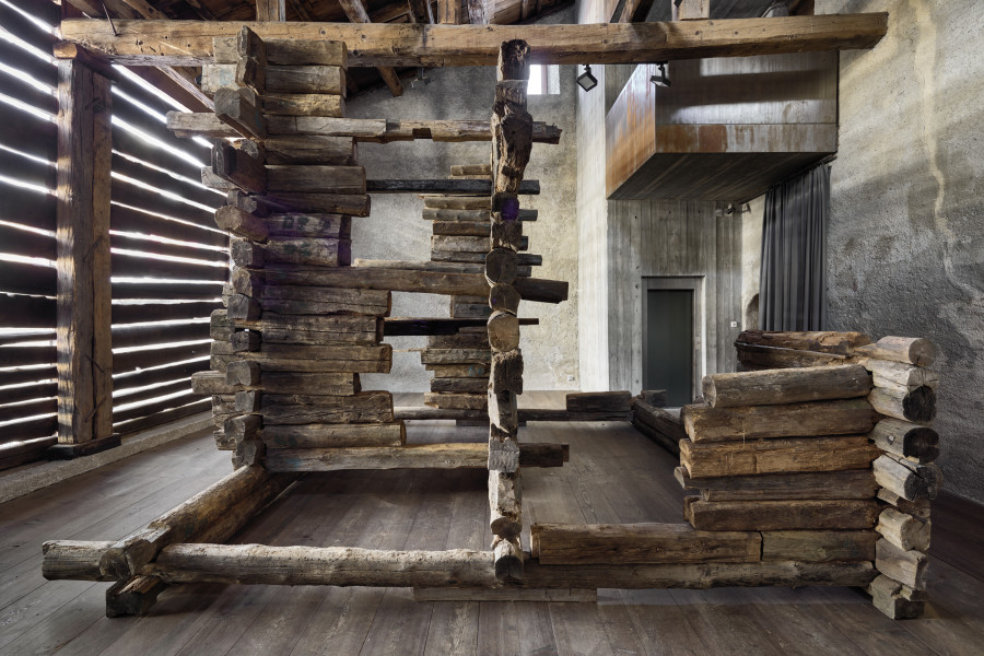 Exhibition view, Augustas Serapinas, Remains of the House from Skirgiškės, 2022, reclaimed wood, 370 x 480 x 500 cm. Photo: Ralph Feiner, Courtesy of the artist and Galerie Tschudi