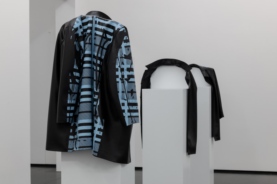 Dominic Michel, Protagonism, 2021-22, Siebdruck auf Kunstleder, Holz, 12 Mäntel: je 160 x 45 x 35 cm, Sockel: Masse variabel. Courtesy Dominic Michel. Foto: ullmann.photography