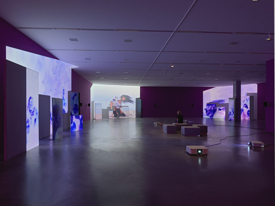 Basel Abbas & Ruanne Abou-Rhame, May amnesia never kiss us on the mouth: Only sounds that tremble through us, 2022, 4-channel video projection (HD, color, sound) on partition wall, metal and concrete panels, photographic gel. Performer: Rima Baransi, Haykal, Julmud, Makimakkuk. Courtesy the artist. Co-commissioned by the Museum of Modern Art, New York, and Dia Art Foundation, New York. Photo: Stefan Altenburger Photography, Zurich