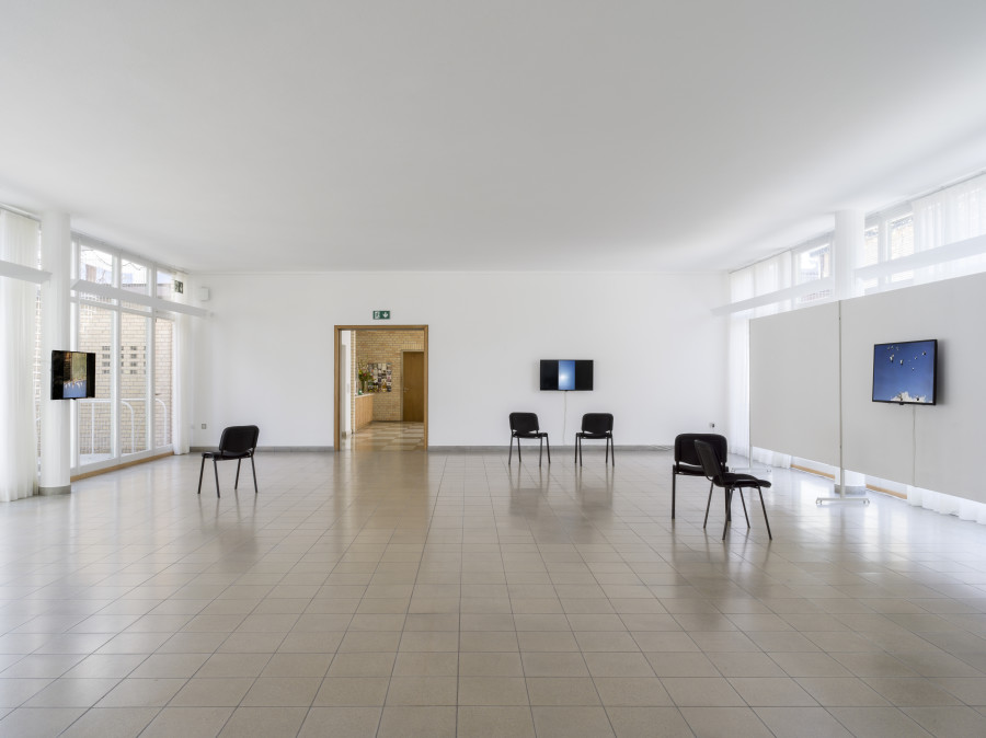 Tourism, Kunsthaus Glarus, 2021, installation view. Lena Youkhana, طيور حمر للبيع في الديواني وهذا رقمي 07819916409 (Red Birds for Sale in Al-Diwaniyah 0781991640), 2015–2016, 7:39 min / طيور عقيل الدعلج مفروده 40 فحل ٠٧٧٠٣٦٧٥٩٨١ (Birds Of Aqeel Al-Daalech, 40 Single Male Birds For Sale 07703670981), 2015–2016, 1:43 min / طيور القماري للبيع في بابل ناحيه النيل (Birds “Al-Qimari” For Sale In Babel Near Al-Neel 07803990790), 2015–2016, 4:26 min / طيور عنابر للبيع (Birds “Anaber” For Sale), 2015–2016, 1:47 min, 4 single-channel videos on monitor (color, sound). Photo: CE